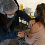 une infirmière fait le vaccin à une patiente.